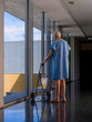 Elderly man in a hospital hallway, using a walker