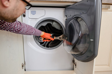 worker in uniform repair a washing machine