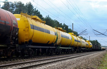 Freight Train With Petroleum Tank Cars On Railroad. Rail Cars Carry Oil And Ethanol. Railway Logistics Explosive Cargo. Transportation Of Methanol, Crude And Gas.Petrochemical Tank Cars