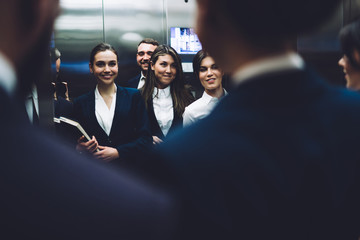 Cheerful coworkers taking elevator together