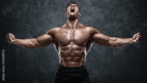 Foto Muscular man showing muscles on wall background