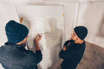 Thiefs making a robbery plan on wall city map