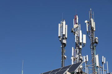 Mobile towers on blue sky background. Many communication equipment.