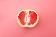 © Victor Moussa - Sexuality, erotic tension and metaphor for female sexual organs concept with grapefruit isolated on pink background