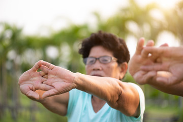 A happy senior couple asian old man and woman standing in summer near mountain and lake during sunrise or sunset . Senior healthcare and relationship concept.