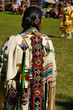 Native Indian woman in traditional buckskin regalia judging a dance competition at a Pow Wow