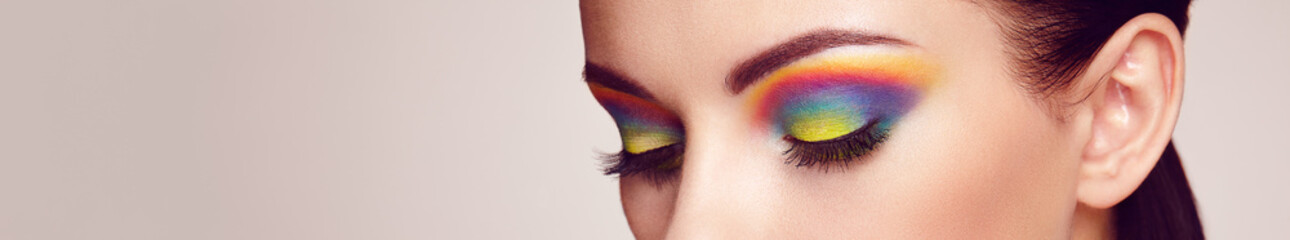 Wall Mural - female eye with rainbow make-up. long eyelashes, vivid colorful eyeshadows. beauty. close up, macro