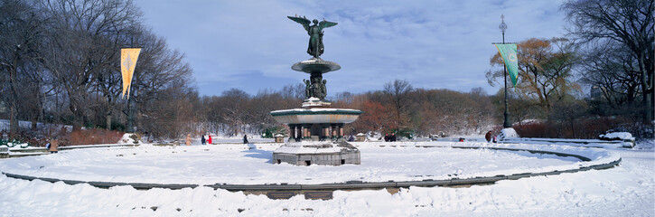 Fototapete - Panoramic view of water fountain covered with fresh winter snow in Central Park, Manhattan, New York City