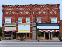 Old Small Town Victorian Building With Fancy Brickwork And Shops With Awnings