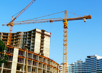 Two cranes near buildings. Construction site background.. Industrial background.