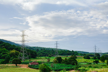 Electricity pole against sunset sky, Transmission line of electricity to rural with green tree, High voltage electricity pole with nature background, electricity transmission pylon