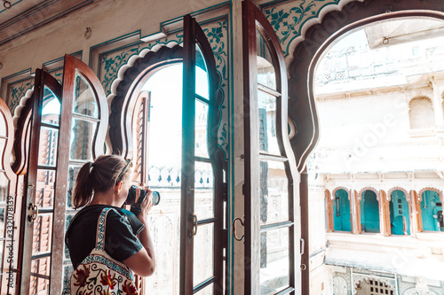 Photo Woman tourist takes photos while visiting the City Palace in Udaipur India