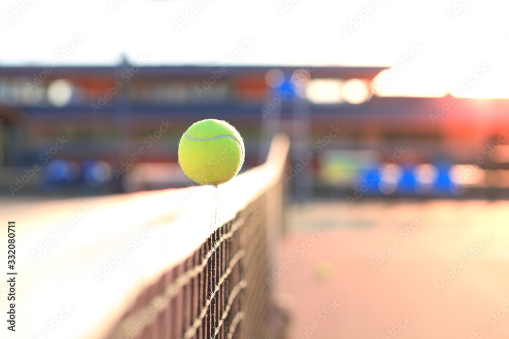Bright greenish yellow tennis ball hitting the net. - obrazy, fototapety, plakaty 