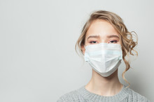 Young Woman Wearing A Face Mask On Gray Background. Flu Epidemic And Virus Protection Concept