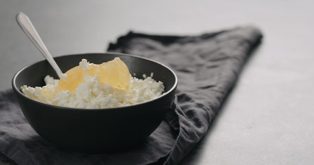 Wall Mural - lemon marmalade with cottage cheese in black bowl closeup