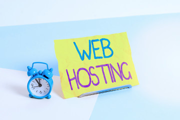 Fototapete - Handwriting text Web Hosting. Conceptual photo business of providing storage space and access for websites Mini size alarm clock beside a Paper sheet placed tilted on pastel backdrop