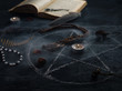 Pentagram circle with a candle , an old book and amulets on the table . The concept of occultism , dark magic, divination or Halloween