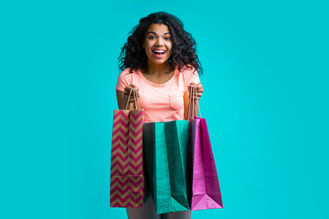 Wall Mural - Attractive young dark skinned woman with a bunch of shopping bags