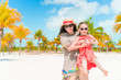 © travnikovstudio - Little adorable girl and young mother at tropical beach