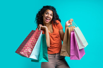 Wall Mural - Attractive young dark skinned woman with a bunch of shopping bags