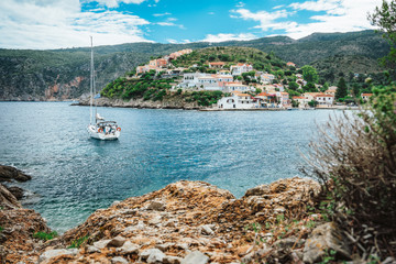 Assos town at Kefalonia. Summer holiday vacation. Sailing boat in the bay on boat trip around Greece islands