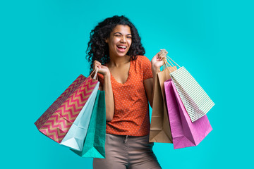 Wall Mural - Attractive young dark skinned woman with a bunch of shopping bags