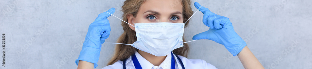 Medical staff preventive gear against coronavirus. Portrait of female doctor with stethoscope in mask. - obrazy, fototapety, plakaty 