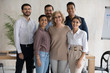 © fizkes - Group portrait of happy diverse multiracial businesspeople look at camera posing together in office, smiling multiethnic colleagues show corporate unity and solidarity at work, teamwork concept