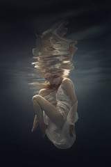 Wall Mural - Portrait of a girl in a beautiful dress underwater