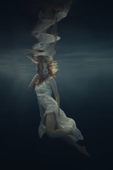 Wall Mural - Portrait of a girl in a beautiful dress underwater