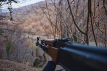 Shooter aiming target with assault rifle weapon. dangerous bandit holding gun in hand. Shooting terrorist with weapon theme decor