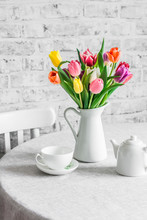 Bouquet Of Tulips , Teapot And Teacup On The Table In The Bright Kitchen. Cozy Home Concept
