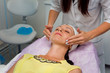 © Nikname - The girl beautician clears the face of the client, preparing for the procedures. Close-up.