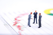 © bung - Miniature people:Businessman standing with team and discuss on the stock trend with copy space. Financial crisis. Data analysis. Stock market volatility risk. Information for investment.