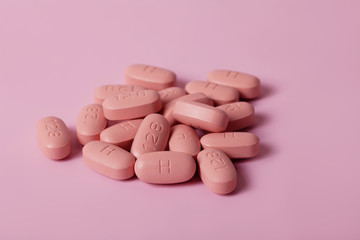 Wall Mural - HIV/AIDS therapy pills on pink background.