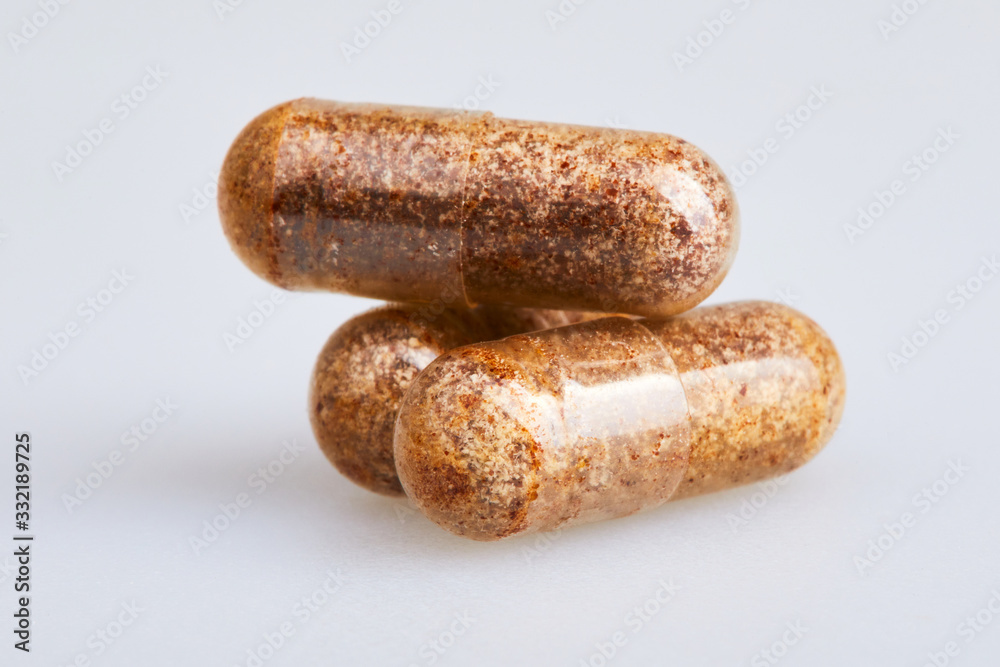 Transparent gelatin capsules with zink powder on white background ...