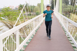 Fototapeta  - Beautiful Asian long hair women running over bridge at public park.Athletic woman jogging in evening time.Workout wellness and healthy lifestyle concept.