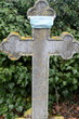 Steinkreuz mit Mundschutz auf einem alten Friedhof