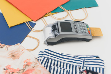 Close up of hand using credit card swiping machine to pay. credit card payment through a shopping terminal. Credit card payment for new clothing collection