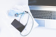 Home Office Medizin - Laptop mit Mundschutz, Stethoskop, Schutz gegen Virus, Infektion, Handy und Sprachassistent. 