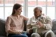 © fizkes - Talk during teatime with aged man, caregiver listens life memories stories of old 75s patient seated on sofa in cozy living room. Provide support care and attention of older generation people concept