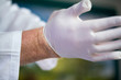Arzt zieht Handschuhe an- Coronakrise, Corona, Coronavirus