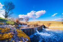 Landscape With A Small Artificial Waterfall. Sunny Weather