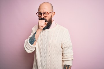 Poster - Handsome bald man with beard and tattoo wearing glasses and sweater over pink background feeling unwell and coughing as symptom for cold or bronchitis. Health care concept.