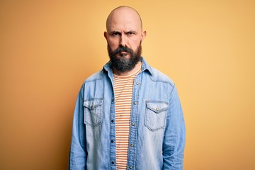 Poster - Handsome bald man with beard wearing casual denim jacket and striped t-shirt skeptic and nervous, frowning upset because of problem. Negative person.