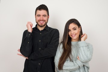 Wall Mural - Image of cheerful pretty young caucasian lady standing against gray wall with hand near face. Looking with glad expression at the camera after listening to good news. Confident girl.