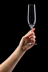 Wall Mural - Woman hand holding empty glass of champagne isolated on black.