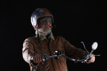 Wall Mural - studio portrait of a vintage biker with a cigar on a black background