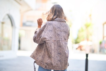 Wall Mural - Young beautiful woman wearing fashion clothes. Standing and walking on backview at town street