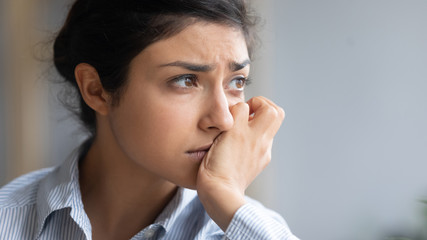 Close up thoughtful depressed unhappy Indian woman thinking about psychological problems, looking away alone, sad upset young female worried about break up with boyfriend, bas relationship